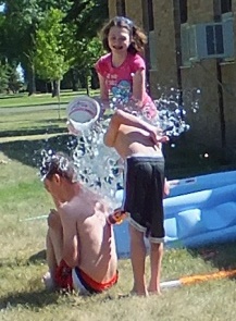 kids dumping water from a bucket on each other